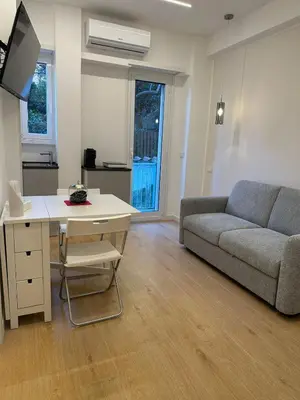 a living room with a couch and a table with a desk at Maryam Vatican Suites in Rome