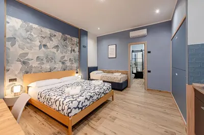 a bedroom with a bed and a table and chairs at Helle Hus - 4 min to Metro, Modern & Quiet, Direct to Colosseum in Rome