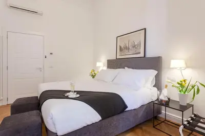 a bedroom with a large bed with white sheets at 504 Corso Suites in Rome