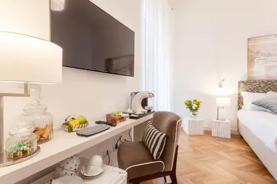 a bedroom with a bed and a desk with a chair at 504 Corso Suites in Rome