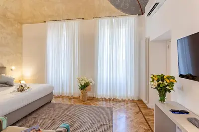 a bedroom with a bed and a television and flowers at 504 Corso Suites in Rome