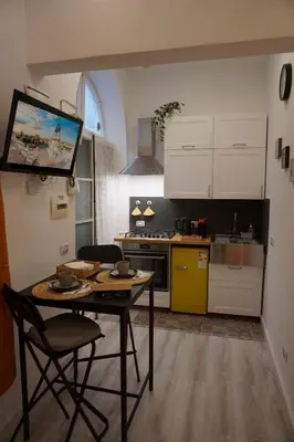 a kitchen with a table and chairs and a tv at Appartamento San Lorenzo di Massimo & Luisa in Rome