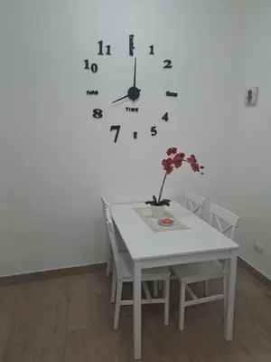 a dining room table with a clock on the wall at 102 DreamHouse metropolitana B Libia in Rome