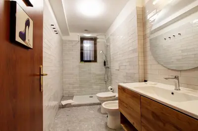 a bathroom with a toilet and a sink and a mirror at San Lorenzo Elegante loft in Rome