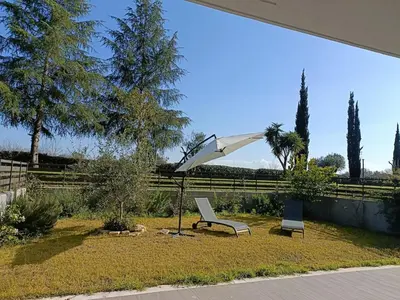 a bench and an umbrella in a yard at Roberta and Luca cozy apartment with garden, terrace and pool in Rome