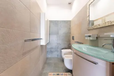 a bathroom with a sink and a toilet and a mirror at Cielo Suite, Panoramic Apt View with Jacuzzi in Rome