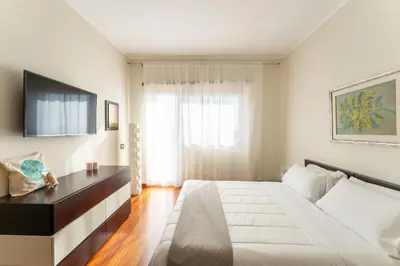 a bedroom with a large white bed and a window at Cielo Suite, Panoramic Apt View with Jacuzzi in Rome