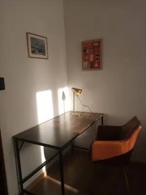 a desk with a lamp and a chair in a room at Appartement familial au coeur de Rome in Rome