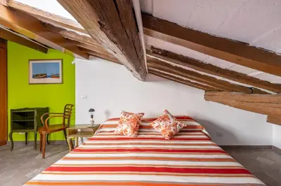 a bed in a room with green walls and wooden ceilings at Fascinating attic - up to 2 guests - Trastevere in Rome