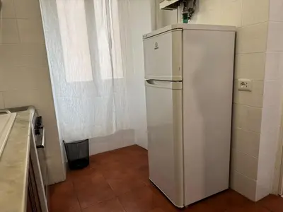 a white refrigerator in a room with a window at Gianicolense sweet Home in Rome