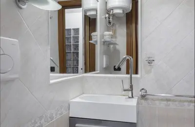 a white bathroom with a sink and a mirror at Rome Studio Centro Storico in Rome