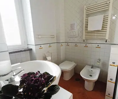 a white bathroom with a tub and a toilet at Home Relax Appia San Giovanni in Rome