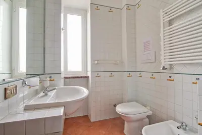 a white bathroom with a sink and a toilet at Home Relax Appia San Giovanni in Rome