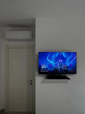 a flat screen tv hanging on a wall at Elegant & Spacious 2BR 2BA Unit with Private Patio in Rome