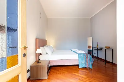 a small bedroom with a bed and a wooden floor at La Grande Casa - City Center in Rome
