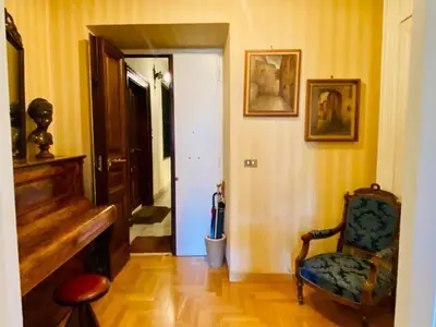 a hallway with a chair and a piano in a room at My Varrone Suite in Rome