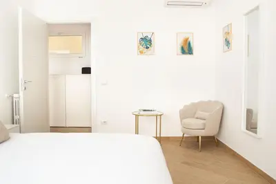 a white room with a bed and a chair and a table at Luxury & Design Apartment Piramide in Rome