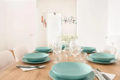 a dining room table with blue plates and glasses at Luxury & Design Apartment Piramide in Rome
