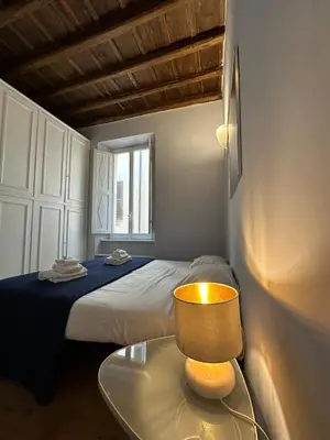 a bedroom with a bed and a table with a lamp at Artist apartment in the heart of Trastevere in Rome
