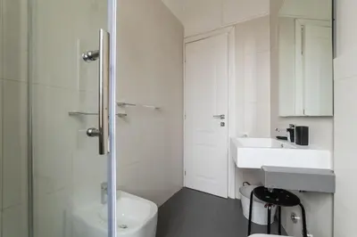 a white bathroom with a toilet and a sink at GuestHost - Trastevere Station Bright Apartment with Terrace in Rome