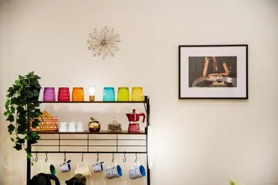a shelf with colorful knick knacks and a clock on a wall at Stella Luxury House - Lombardia in Rome