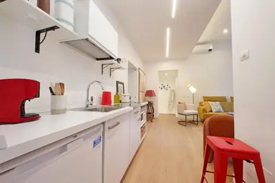 a kitchen with white cabinets and a red stool at Scipioni2 in Rome