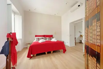 a bedroom with a red bed with a red blanket at Scipioni2 in Rome
