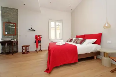 a bedroom with a bed with a red blanket on it at Scipioni2 in Rome
