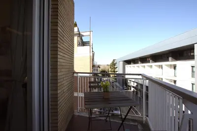 a balcony with a wooden bench and a table at Vigna Clara 2BR Holiday House in Rome
