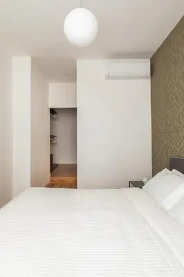 a bedroom with a large white bed and a hallway at Casa Dante in Rome