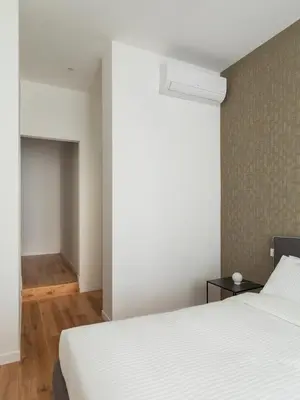 a bedroom with a white bed and a wall at Casa Dante in Rome