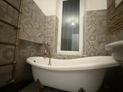 a white bath tub in a bathroom with a mirror at Rome Piazza di Spagna Guesthouse in Rome