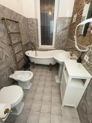 a bathroom with two toilets and a tub and sinks at Rome Piazza di Spagna Guesthouse in Rome