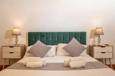 a large bed with a green headboard and two night stands at Mazzini 38 in Rome