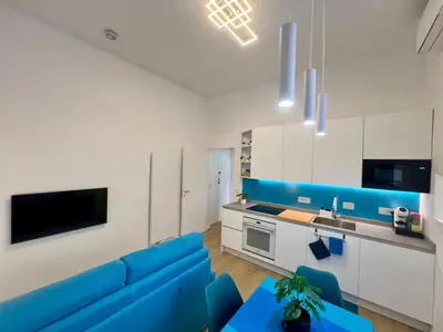 a living room with a blue couch and a kitchen at Trastevere ON in Rome