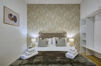 a bedroom with a large white bed with two lamps at Silver Loft San Giovanni in Rome