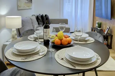 a table with plates and wine glasses and fruit on it at Silver Loft San Giovanni in Rome