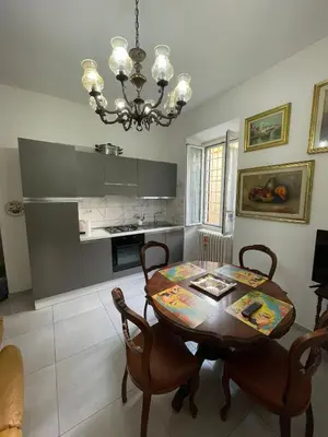 a kitchen with a table and chairs and a chandelier at Rachel house in Rome
