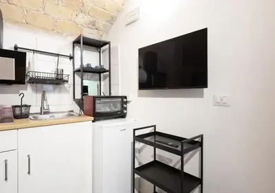 a kitchen with a tv hanging on a wall at Paradise Vatican Home in Rome