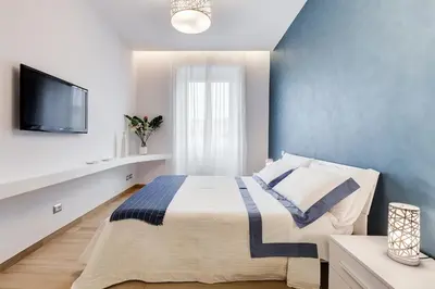 a bedroom with a bed with a blue wall at Vatican Brothers in Rome