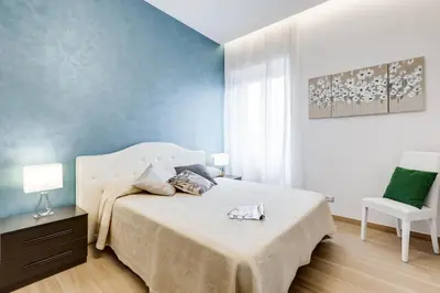 a bedroom with a white bed and a chair at Vatican Brothers in Rome