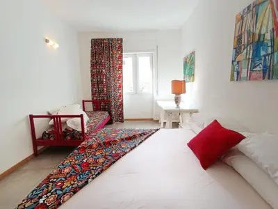 a bedroom with a large white bed with red pillows at A Casa di Adriana in Rome