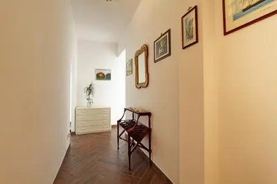 a hallway with a chair and pictures on the wall at A casa di Chloe - Ponte Milvio in Rome