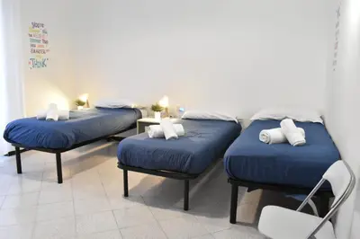 three beds in a room with blue pillows at Teresa Amor INN Roma in Rome