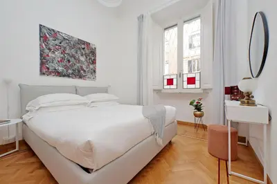 a white bedroom with a white bed and a mirror at TreasureRome Adriana Charme 4BR in Rome
