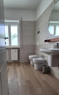 a bathroom with two sinks and a toilet and a window at Nuovissimo appartamento zona Vaticano Aurelio in Rome