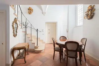 a staircase with a table and chairs in a room at Beatrix Apartment in Trastevere by Nosdom Properties in Rome