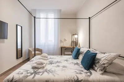 a bedroom with a large bed with blue pillows at Appartamento fino a 17 persone in centro a 17 minuti a piedi da Piazza di Spagna in Rome