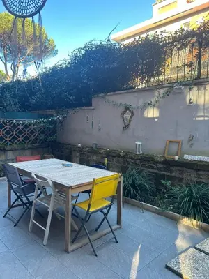 a wooden table and chairs in front of a building at Happy House with private garden in Rome