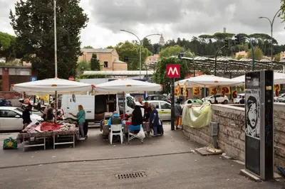 a group of people sitting under umbrellas at a market at Vatican Manu Home in Rome